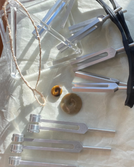 Various sound instruments including weighted and unweighted tuning forks, two stone donuts used to facilitate vibration and a crystal pyramid.